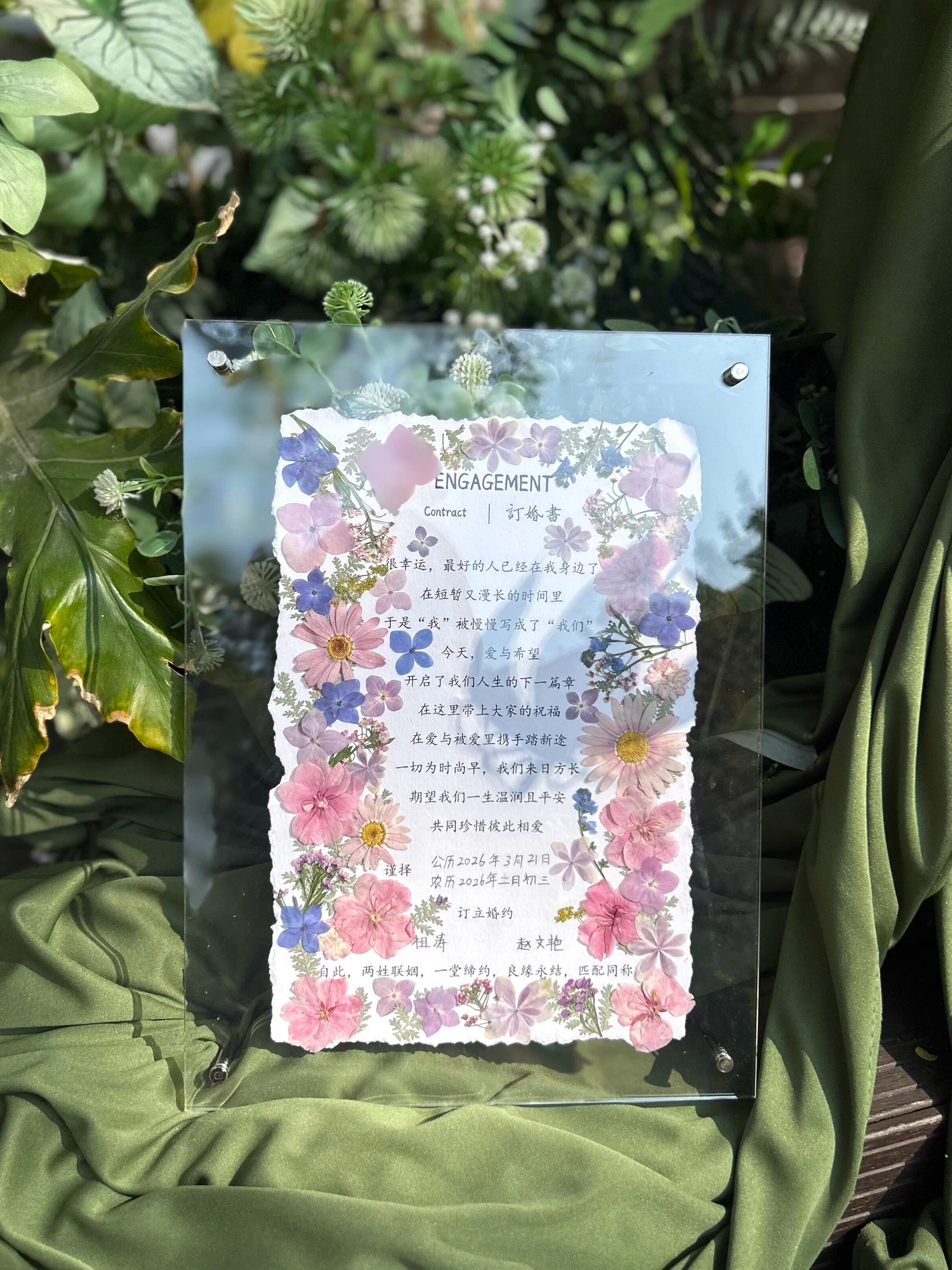 Pressed flower engagement book displayed in a frame