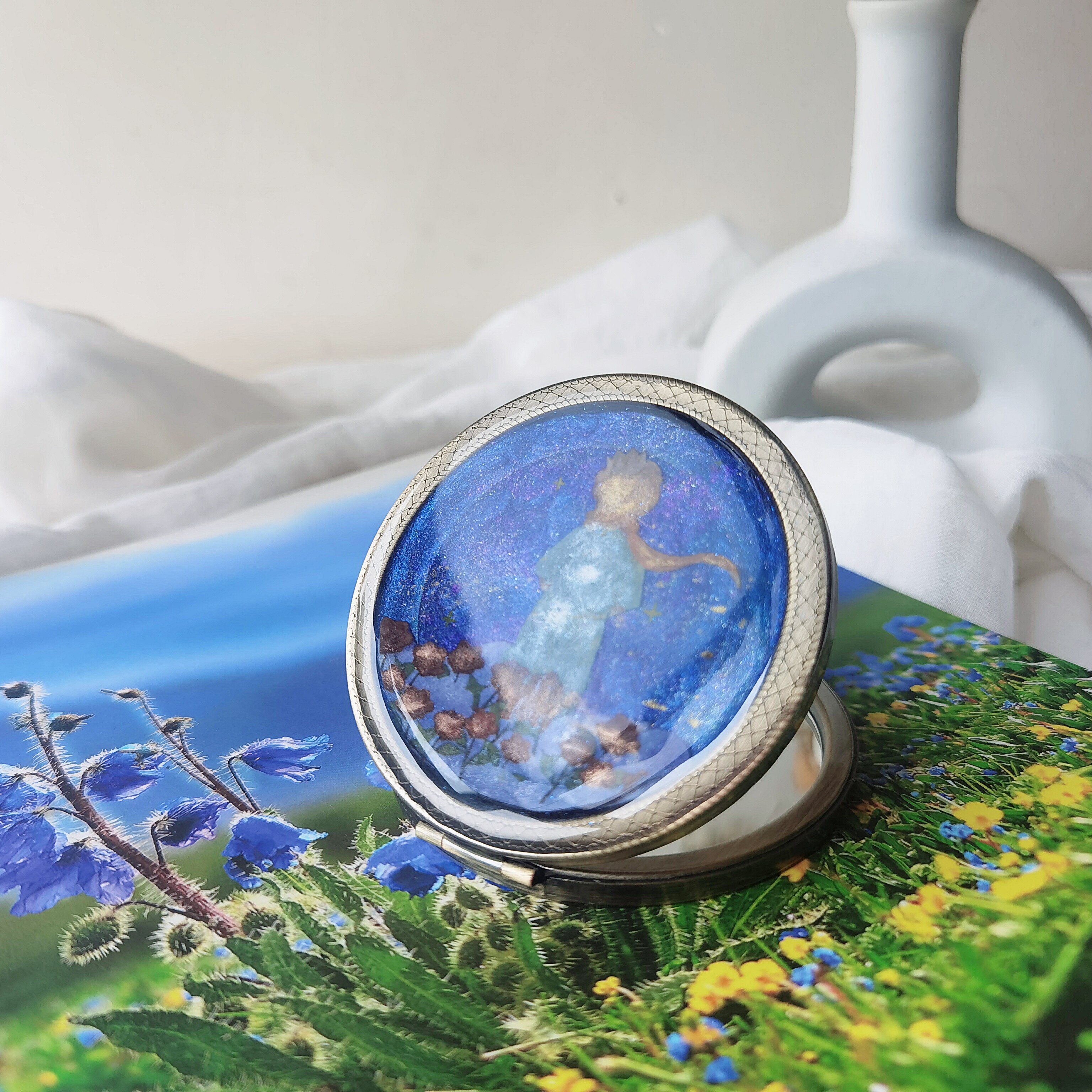 Folding hand mirror with pressed flower framing and a keepsake window