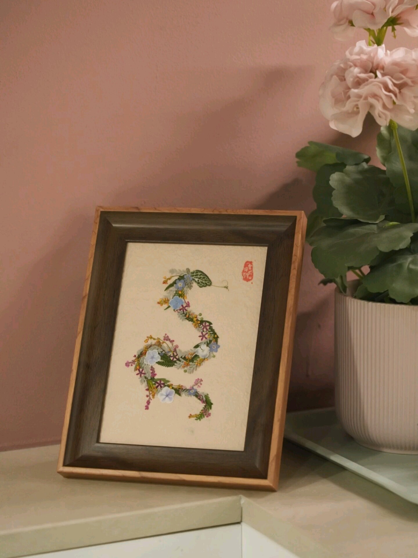 Framed pressed flower art with a zodiac motif